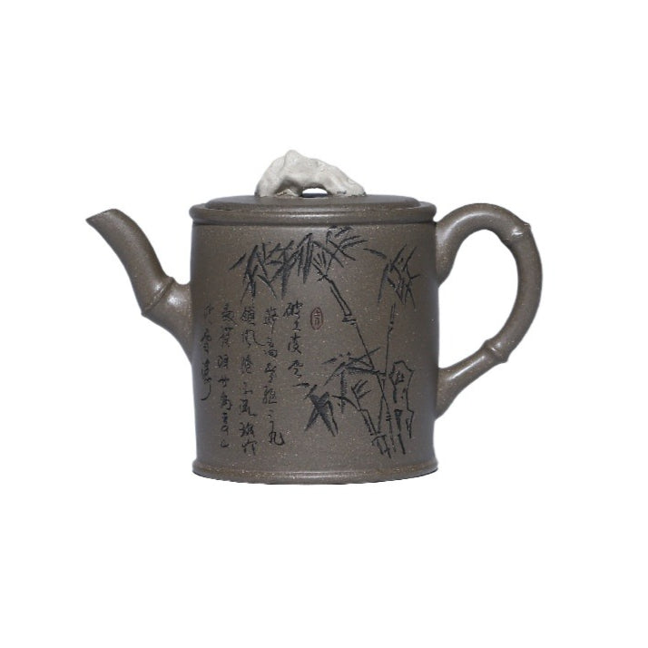 Grey-brown cylindrical teapot with bamboo decoration, on a white background.
