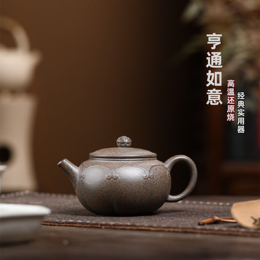 Grey-brown Dezhong teapot with raised scroll decoration, on a tea table with Chinese text above.