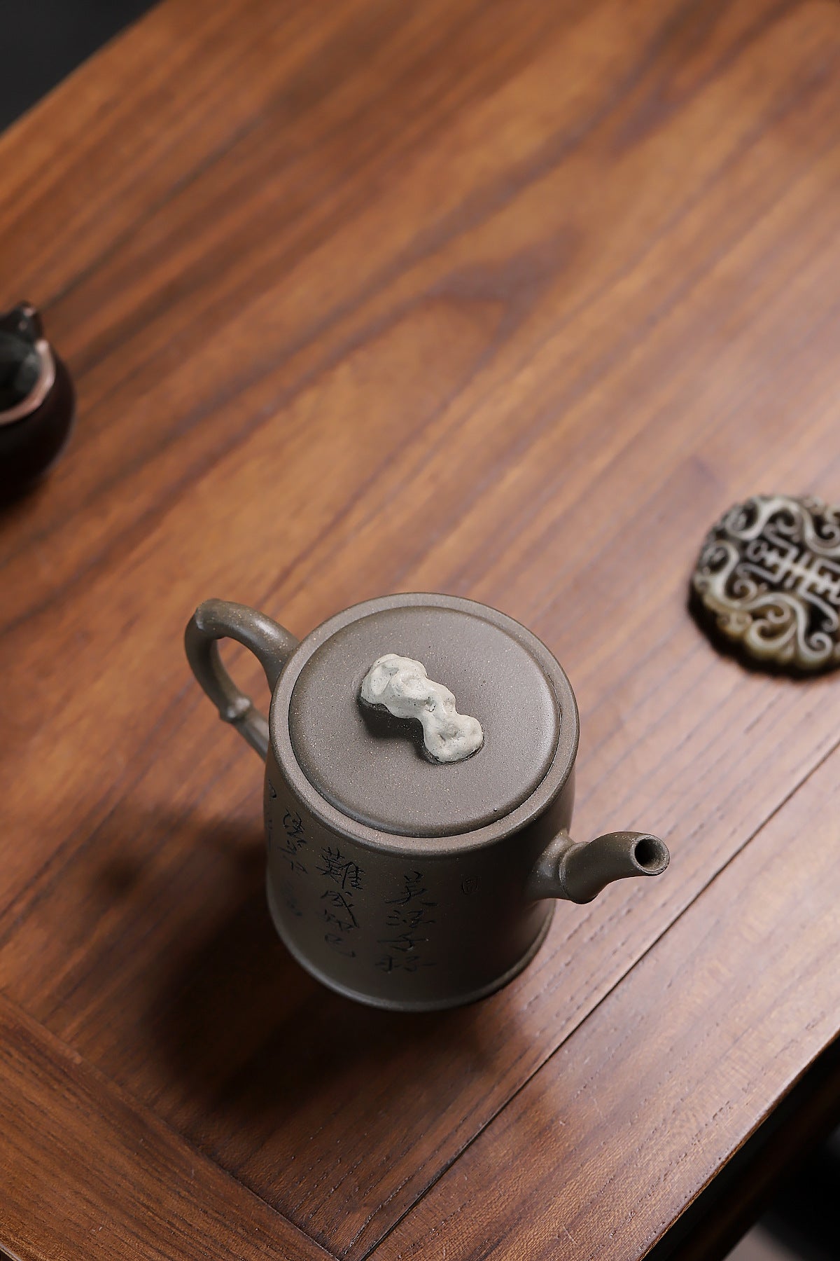 Grey-brown cylindrical teapot with bamboo decoration, overhead view of the lid ornament.